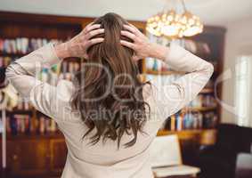 Stressed woman by chandelier and bookshelves in room