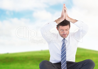 Businessman Meditating by green field
