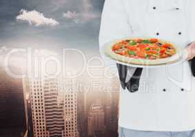 Chef with pizza against blurry skyline