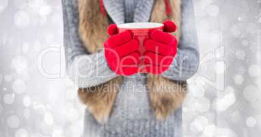 Woman mid section with red coffee cup against white bokeh