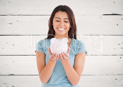 Woman with piggy bank against white wood panel