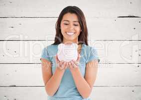 Woman with piggy bank against white wood panel