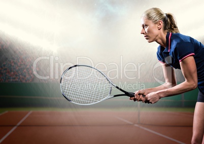 Tennis player with racket outstretched on court with audience and bright lights