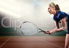 Tennis player with racket outstretched on court with audience and bright lights