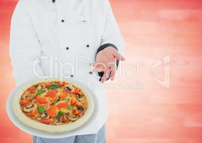 Chef with pizza against blurry red wood panel