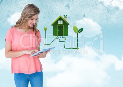 Woman with tablet and green house graphic against sky