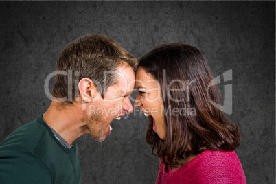 Angry couple shouting at each over against grunge wall