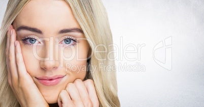 Close up of woman with hand on face against white wall