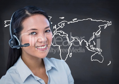 Travel agent with headset against white map and navy chalkboard