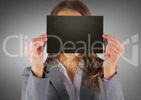 Business woman with black blank card over face against grey background