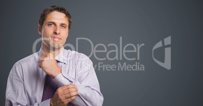 Man in lavender shirt holding arm against grey background