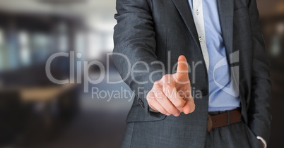 Business man mid section pointing in blurry room