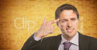 Business man finger on temple against yellow brick wall