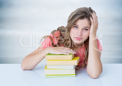 Woman with books at desk against blurry grey wood panel