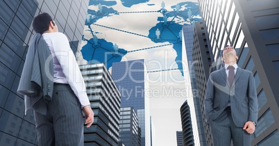 Businessmen looking up in tall City with world map and people networks