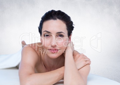 Woman lying on front against white wall