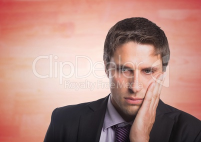 Business man hand on face against blurry red wood panel