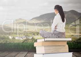 Woman sitting on Books stacked by landscape mountains