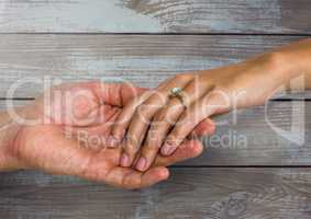 Wedding engaged couple holding hands against wood