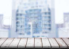 White wood table against blurry building