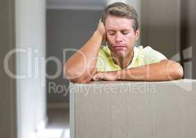 Sad man with cardboard box parcel against hall
