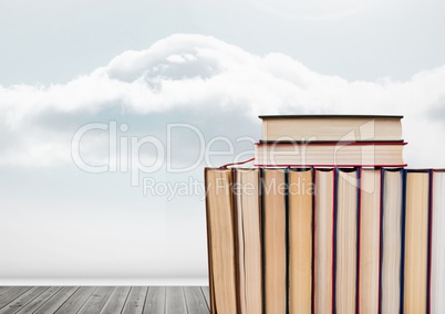 Books stacked by cloudy sky