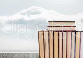 Books stacked by cloudy sky