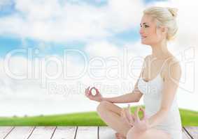 Woman Meditating by green field