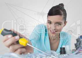 Woman with electronics and screwdriver against white background with graphs