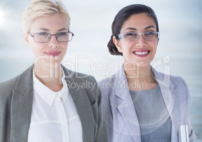 Two business women with flare against blurry grey wood panel