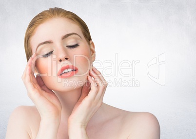 Woman with hands on face against white wall