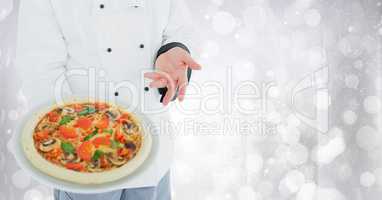Chef with pizza against blurry white bokeh