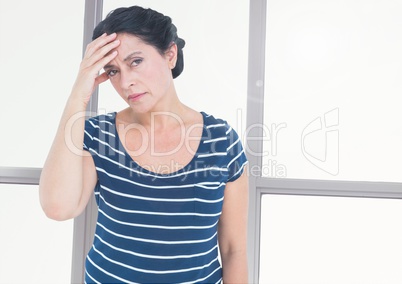 Stressed tired woman in front of windows