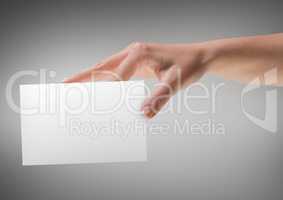 Hand with blank card against grey background