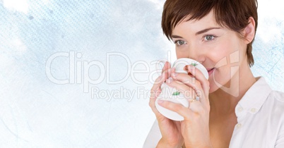 Woman drinking from mug against pale sky