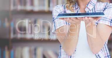 Womans hands holding tablet in Library
