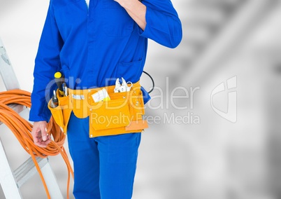 Handyman lower body with ladder against blurry grey stairs