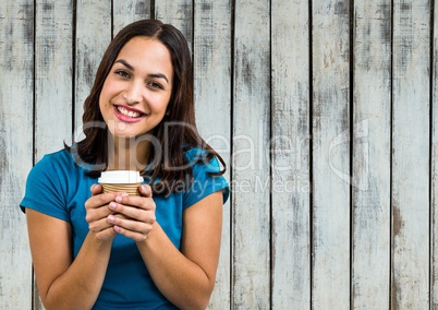 Woman in blue tshirt with coffee cup against wood panel