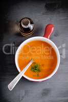 Pumpkin creme soup with a spoon served on a table.