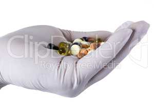 Pharmaceutical pills on a hand in latex glove
