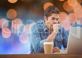 Man with laptop and coffee against blue and orange bokeh