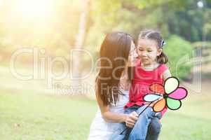 Asian mother and daughter playing windmill in the park.