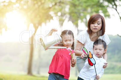 Asian mother and children playing at outdoor park.