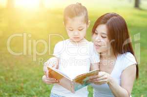 Mother and daughter reading outdoors.