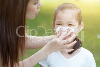 Little girl blowing nose.