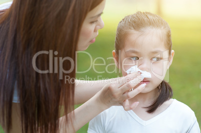 Flu season, little girl blowing nose.
