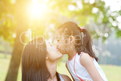 Mother and daughter kissing.