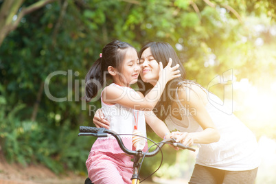 Mother and daughter riding bike and having fun.