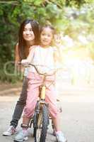 Parent and child biking outdoor.