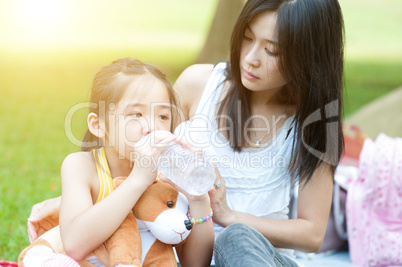 Mother comforting child and drinking water.